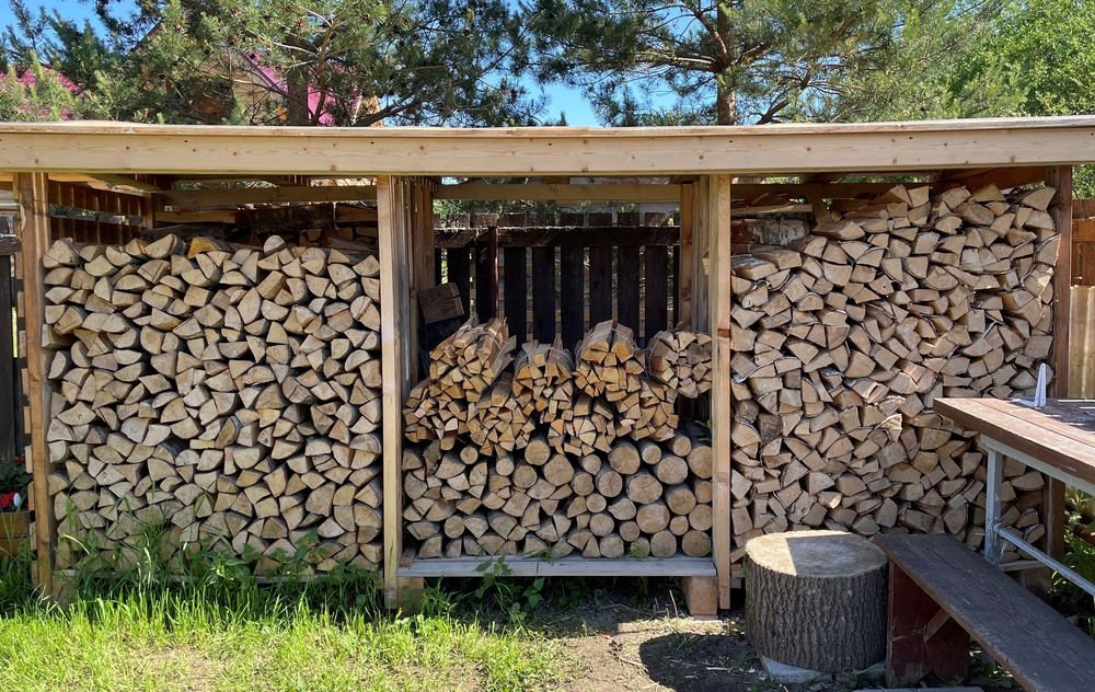 Storage,of,firewood,under,a,canopy,in,the,yard.,chopped